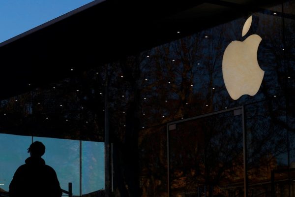 Un hombre pasa junto a un logo de Apple en Aix-en Provence, Francia.